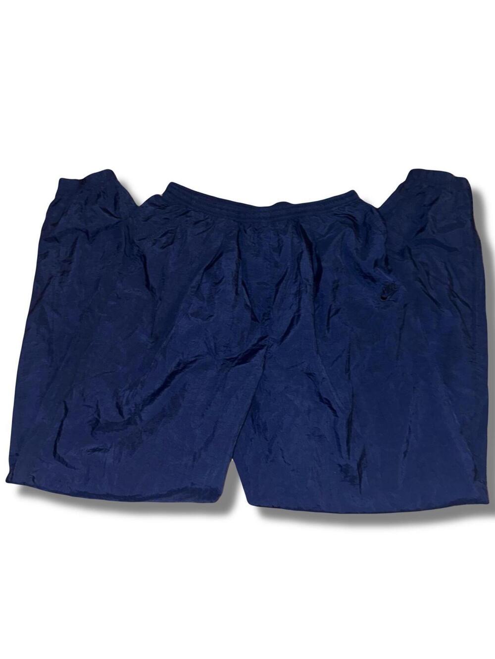 Vintage 90s Nike navy blue track pants with drawstring waist and zipper legs